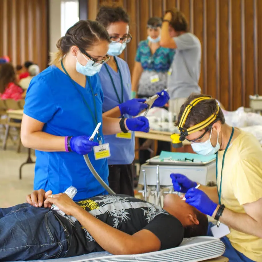Team member examining patient's teeth