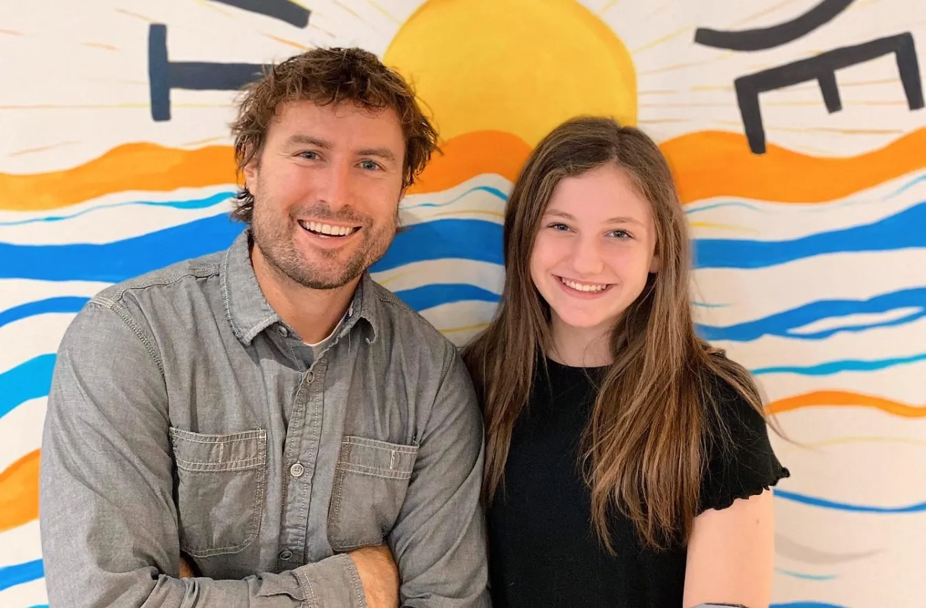Smiling orthodontist and child in front of colorful mural promoting confidence and joy through Invisalign for kids at True Smile Orthodontics.